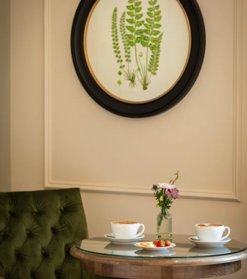 Cosy seating with cappuccinos and flowers at Fernhill House Hotel.