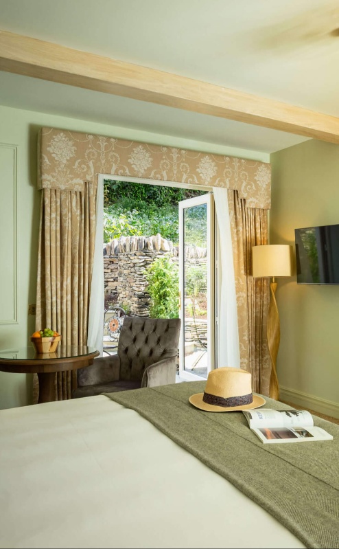 Elegant hotel room with garden view, featuring a king-sized bed and classic decor.
