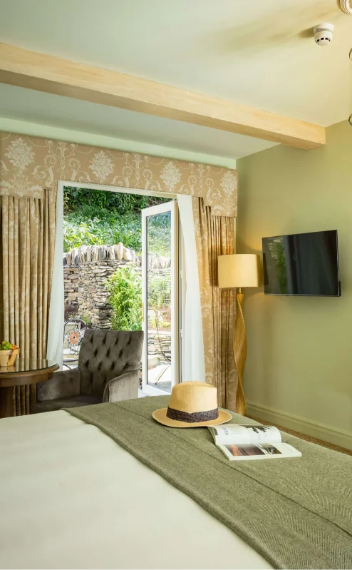 Cosy hotel room with garden view, family exploring outdoors.