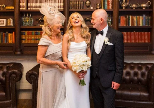 A joyful couple with bride in elegant library setting at Fernhill House Hotel.
