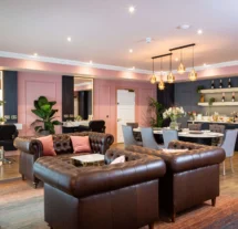 A cosy lounge in Fernhill House Hotel with leather sofas, dining tables, and elegant lighting.