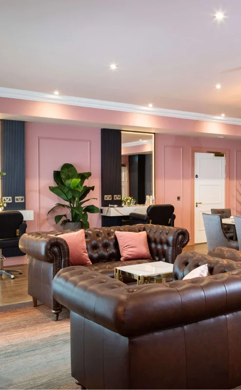 A cosy lounge in Fernhill House Hotel with leather sofas, dining tables, and elegant lighting.