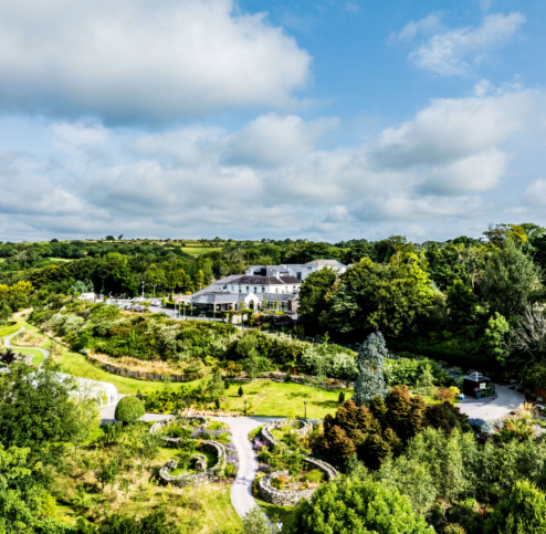 Lush gardens and scenic view at Fernhill House Hotel on a sunny day.
