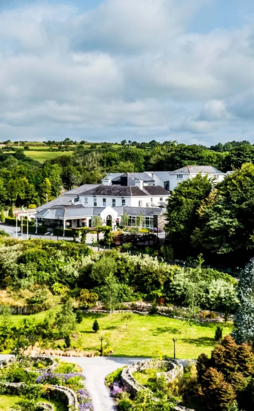 Aerial view of Fernhill House Hotel surrounded by lush gardens and countryside.