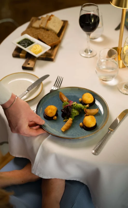 Elegant dish served at a fine dining table with wine and bread.