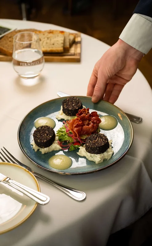 Elegant dining setup with a gourmet dish at Fernhill House Hotel