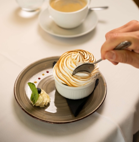 A person enjoys a dessert with coffee at Fernhill House Hotel.