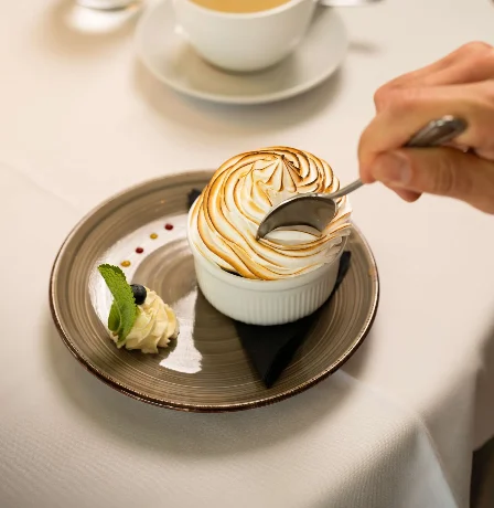 Elegant dessert with meringue swirl in a cosy dining setting at Fernhill House Hotel.