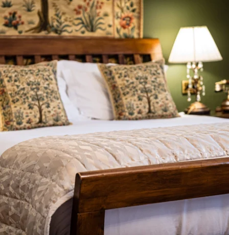 Elegant hotel room with a cosy bed, soft lighting, and nature-themed decor.