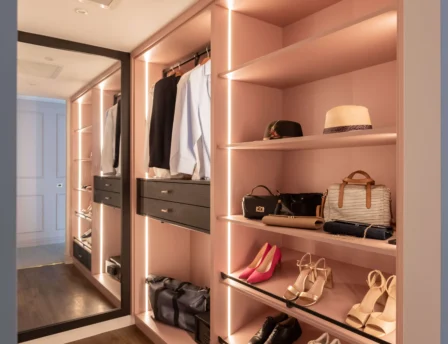 Elegant hotel wardrobe with clothes, shoes, and bags, creating a cosy atmosphere.