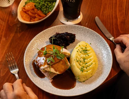 Cosy dining with hearty meal and stout at Fernhill House Hotel.