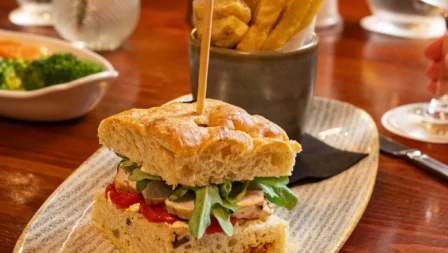 Family dining at Fernhill House Hotel with gourmet sandwich and chips on a wooden table.