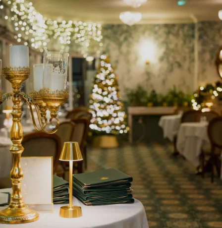 Elegant dining room with festive decor and a Christmas tree.