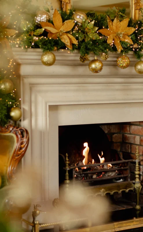 Cosy fireplace with festive decorations and warm ambience at Fernhill House Hotel.