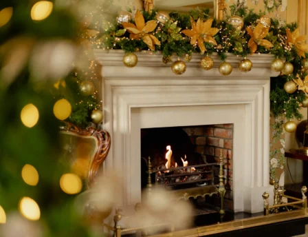 Cosy fireplace with festive decorations in a welcoming hotel lounge.